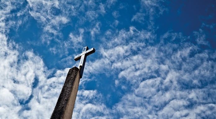 La Iglesia, maestra Cruz silueteada en el cielo