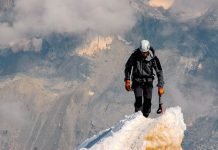 Fortaleza y humildad Montañero en la cima simboliza el esfuerzo espiritual de alcanzar la fortaleza desde la humildad.