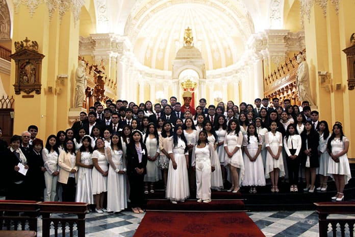 Grupo de jóvenes confirmandos junto al obispo Jóvenes universitarios confirmandos junto al arzobispo de Arequipa tras la ceremonia en la catedral.