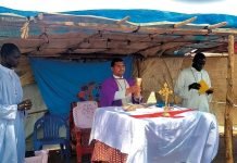 El sostén silencioso de los sacerdotes en los rincones más desamparados del mundo Sacerdote africano celebrando misa en una comunidad rural, rodeado de fieles.