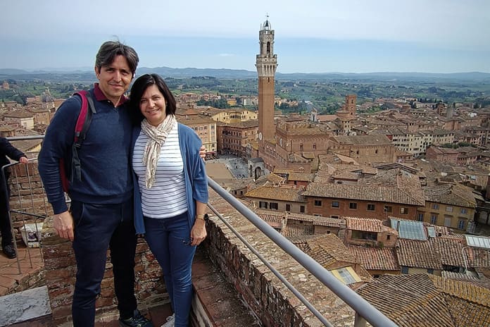 José Miguel y Beatriz Lahoz José Miguel de la Peña y Beatriz Lahoz posan ante la Torre del Mangia en Siena, símbolo de belleza arquitectónica italiana.