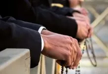 María, Madre del Rosario Manos sosteniendo un rosario en oración como signo de devoción mariana.