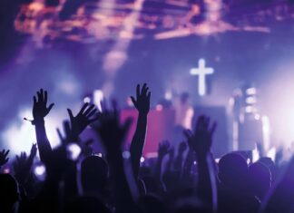 El posible giro católico del siglo XXI: ¿moda, búsqueda o cambio profundo? Jóvenes levantan las manos en un concierto, símbolo de búsqueda espiritual y sentido en la cultura contemporánea