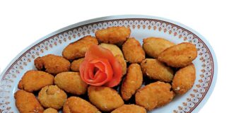 Croquetas de langostinos Fuente de croquetas de langostinos caseras recién fritas, acompañadas de ensalada mixta con lechuga, tomate y aceitunas negras