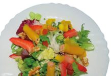 Ensalada de brotes con canutillos de mango y paté Primer plano de una ensalada de brotes tiernos con canutillos de mango rellenos de paté, nueces y fresas